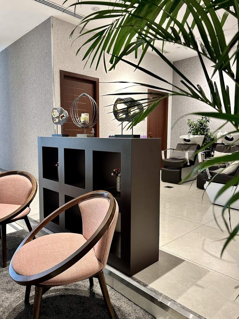A blush chair and plant in a quiet corner